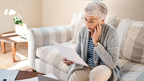 A lady looking at her bills.