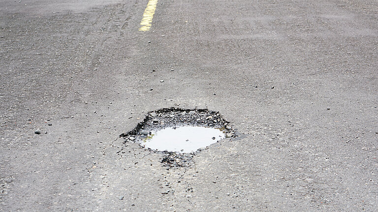 A pothole filled with water.