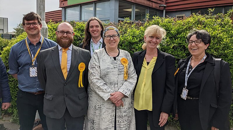 A group of smiling Reading Liberal Democrats in front of a leafy hedge